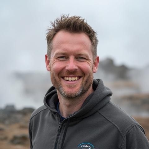 Professional headshot of Liam O'Connell in a field of geothermal vents.